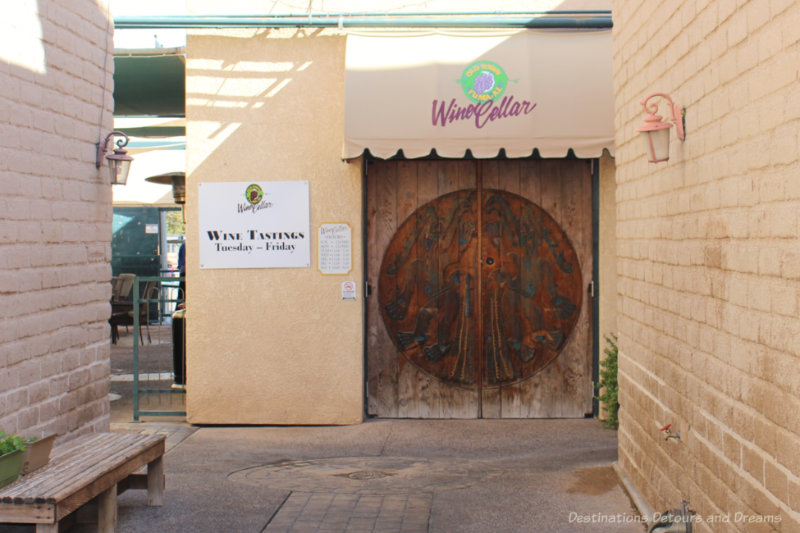 Entrance door with large wood carved wheel on it into a wine store