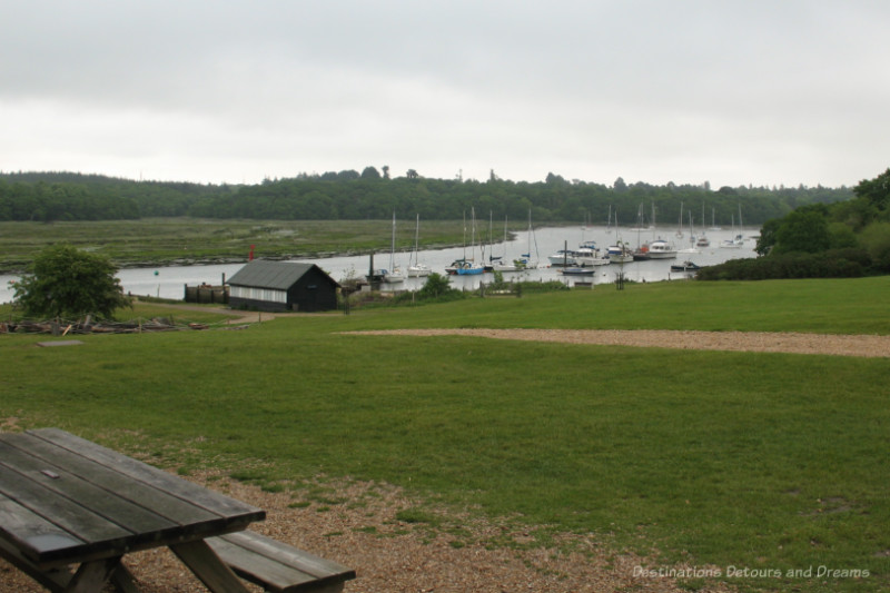 Grassing area in front of and behind river lined with pleasure boats