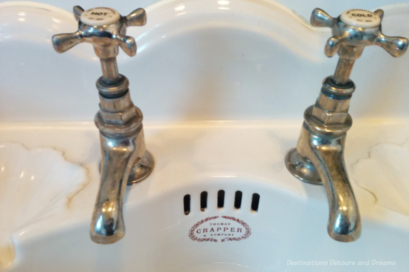 Wash basin with hot and cold taps and Thomas Crapper logo emblazoned on porcelain bowl