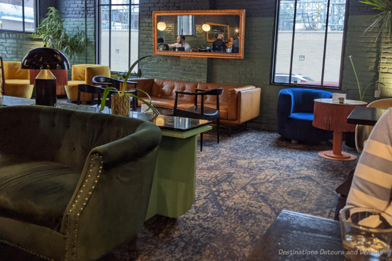 Sofas seating and round tables with curved armchairs in a brick walled taproom