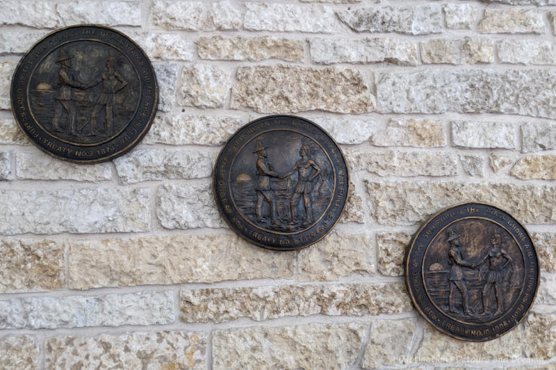 Three round carved disks hanging on a brick wall
