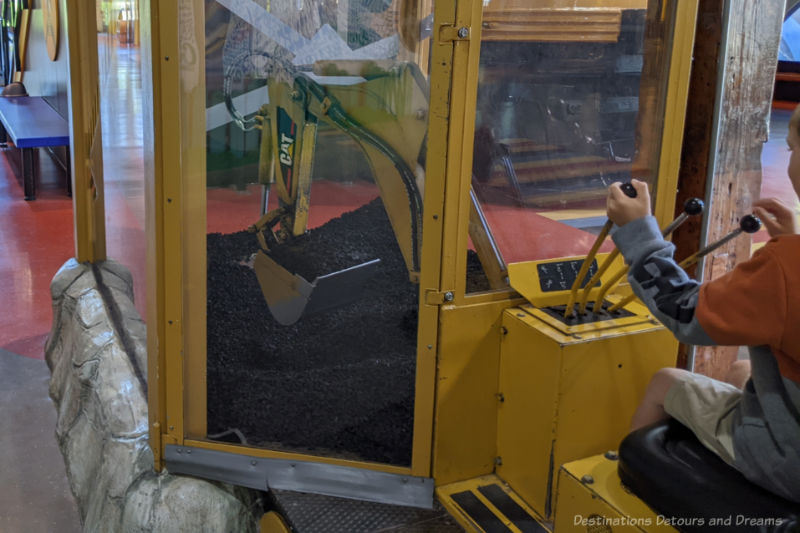 Child manipulating an excavator at a children's museum