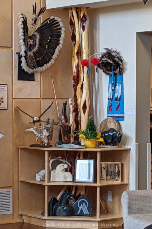 Shelving in a corner displaying Indigenous art pieces