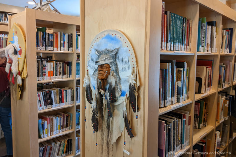 Library shelves with Indigenous art displayed on the ends