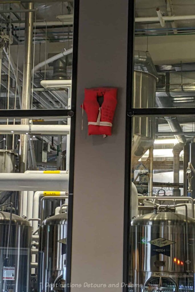 Wall with windows on either side into brewery has life jacket hanging on it