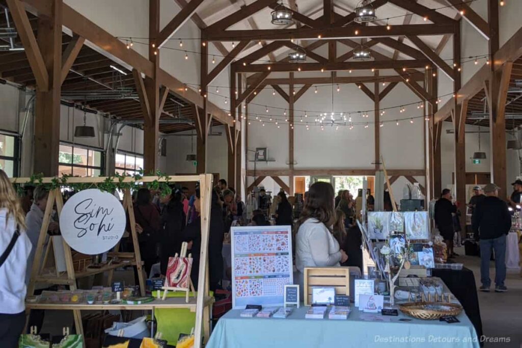 Farmer and craft market set up inside at wood-raftered building