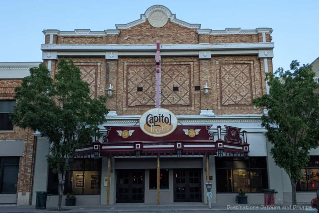 Historic theatre built in the early 1900s with patterned brick design and maroon-coloured marquee