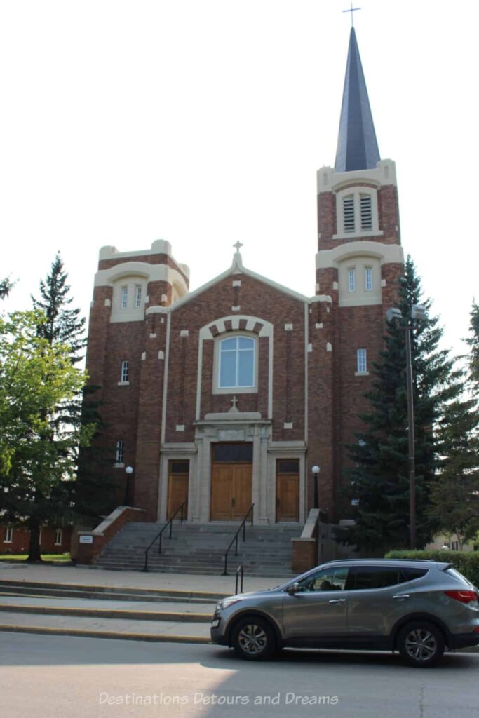 Brick century-old church with steeple towers on either side but only one built steeple.