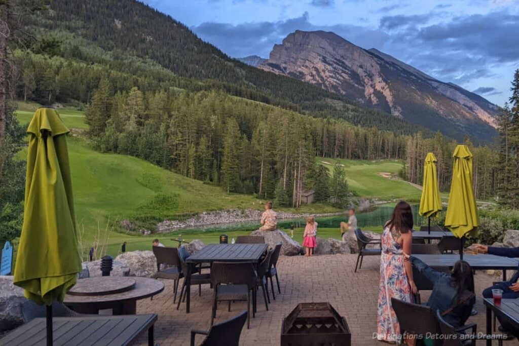 Patio area overlooking small pond with mountains in background