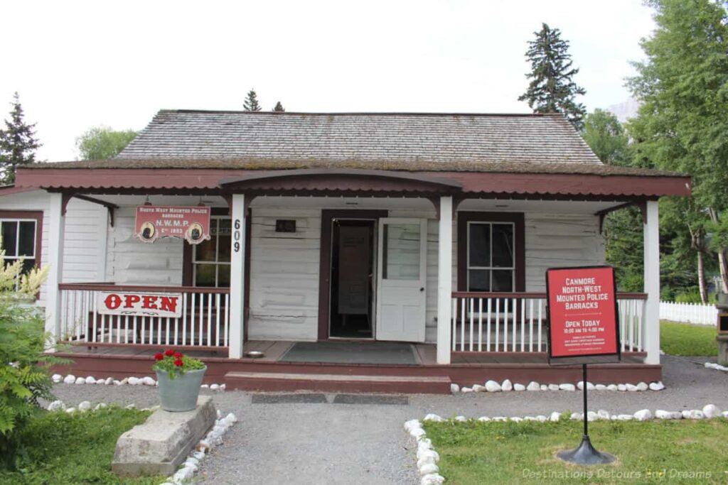 White wood one-story building with wide front porch running its width that was the 1893 police barracks