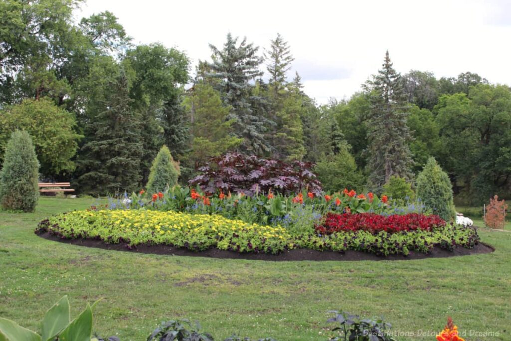 Circular flower bed with evergreens in the background