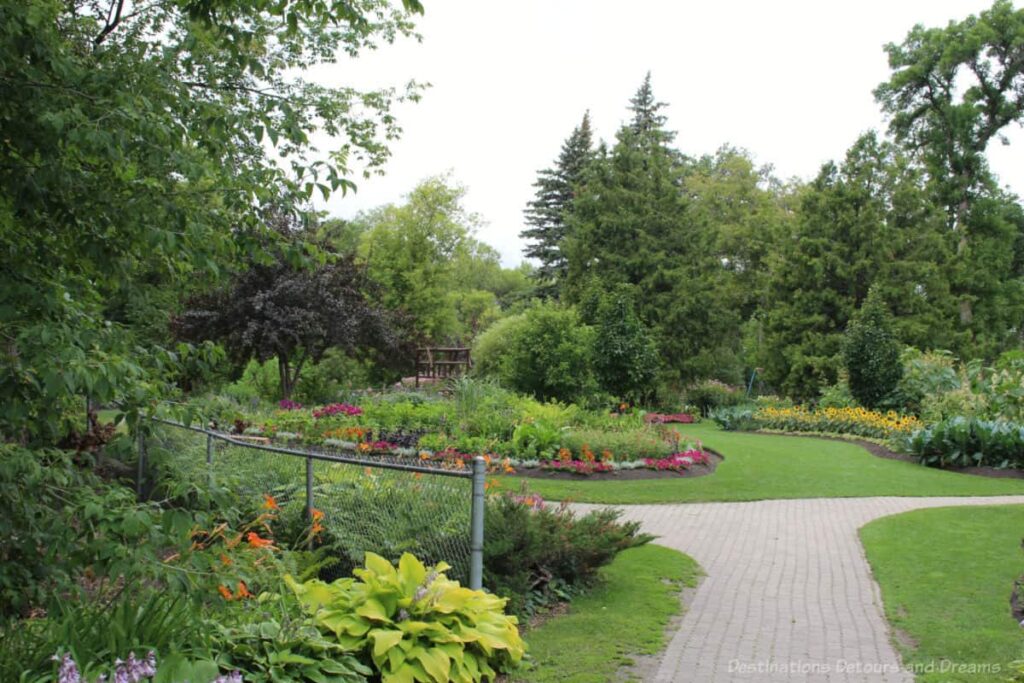 Path leading into green space with garden beds and trees