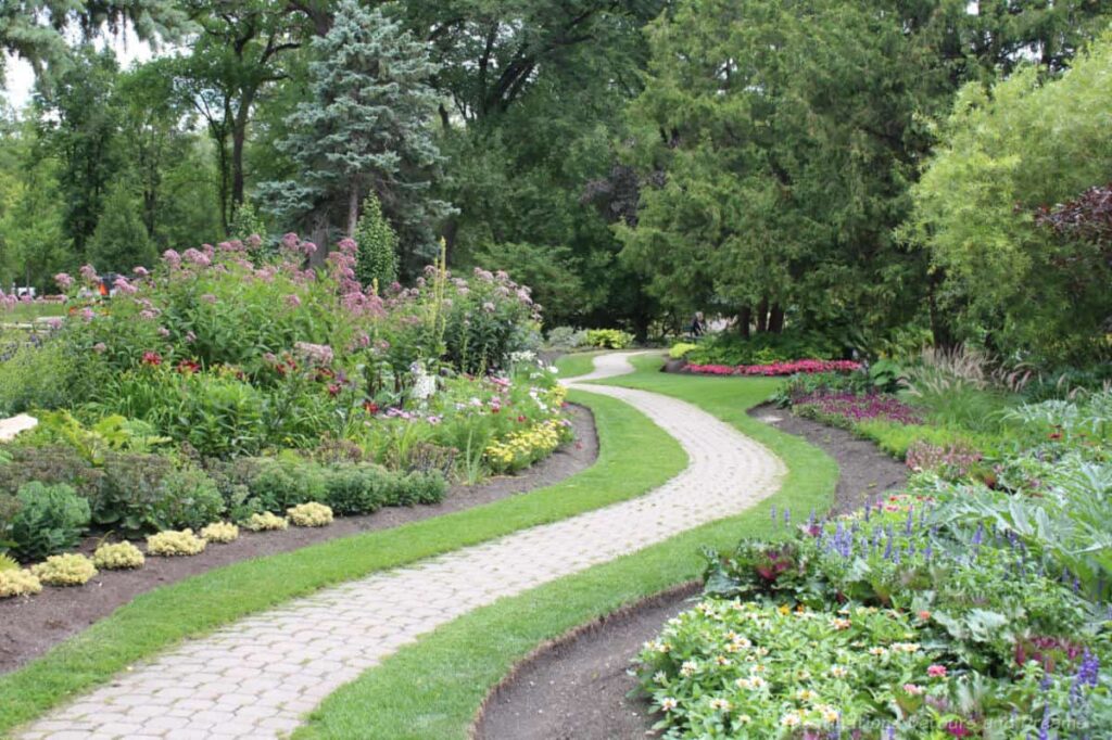 Interlocking stone pathway through flowers beds and trees