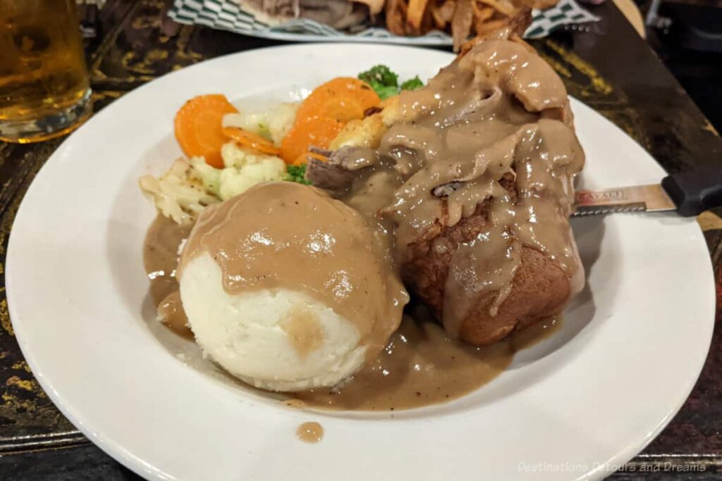 Yorkshire Pudding stuffed with slow-roasted beef, accompanied with mashed potatoes and vegetables