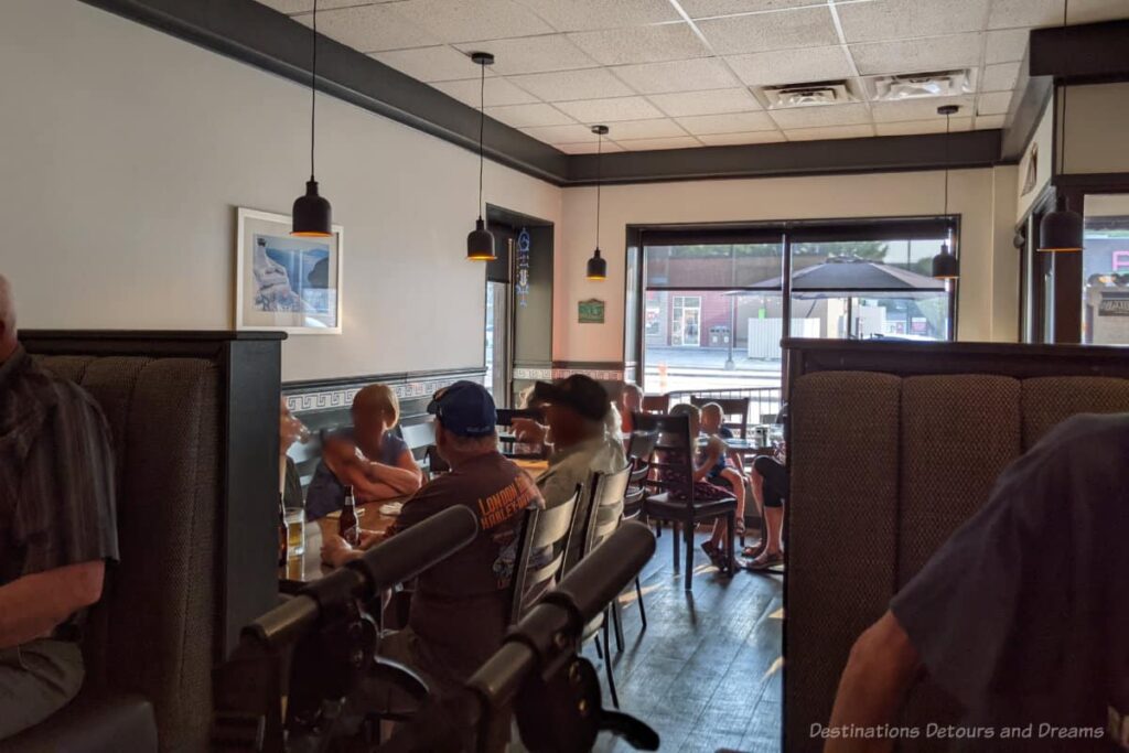 Interior of basic restaurant with a few tables and large window to street