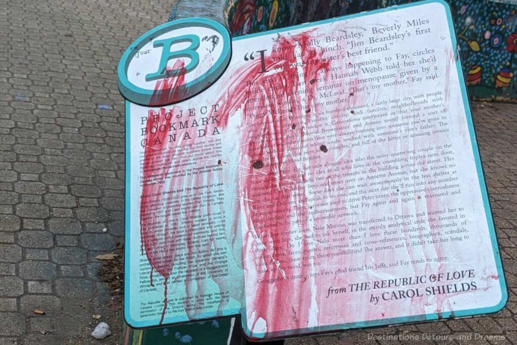 Project Bookmark Canada placard containing book excerpt defaced by red paint