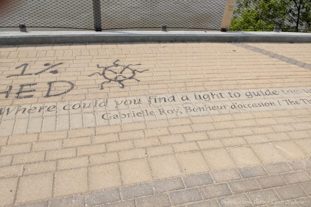 Words from a Gabrielle Roy book on a brick walkway