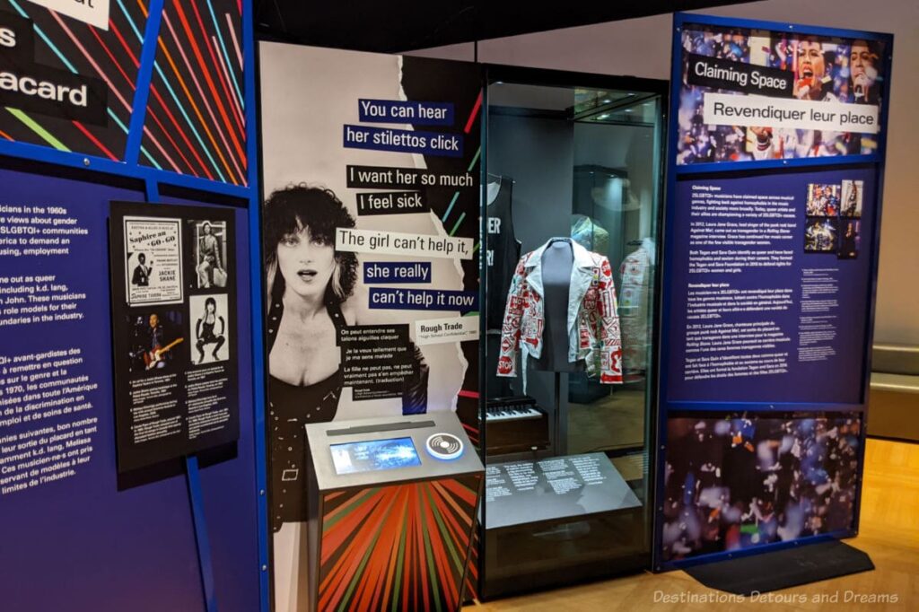 Display panels featuring photos, text, and a cabinet with a jacket in it at an exhibition