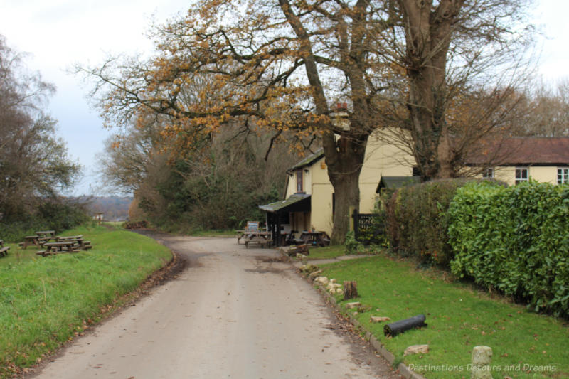 Pub at the end of an English country lane with grassy area and picnic tables