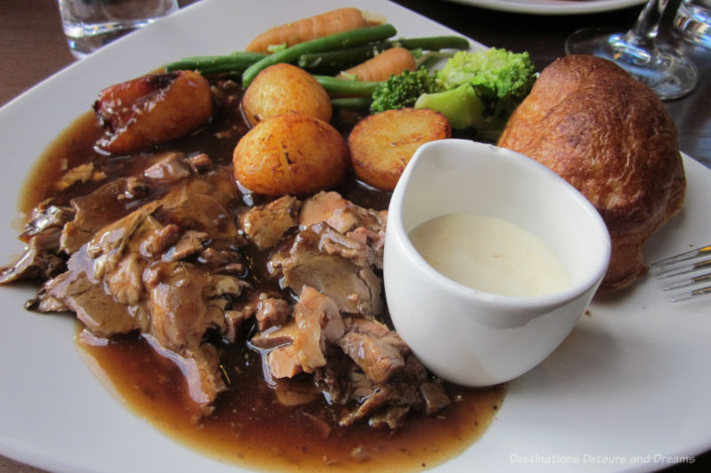 Plate with an English roast meal with potatoes, gray, broccoli and Yorkshire pudding