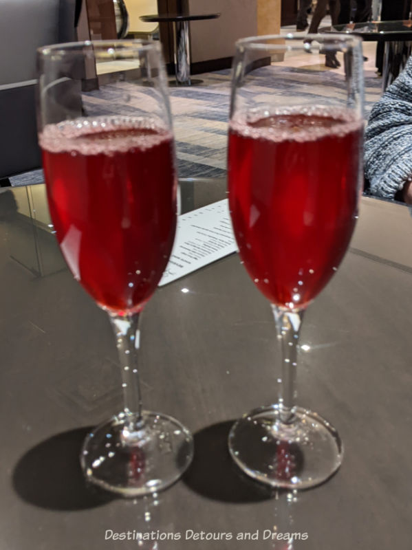 Le Petit Chef Welcome Drinks Two champagne glasses containing a reddish beverage