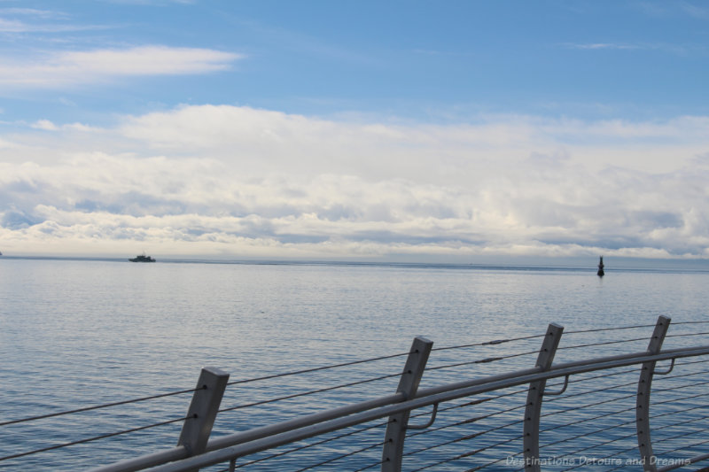 Ogden Point Breakwater Water View Viuew of ocean and clouds from behind fence of aluminum and stainless steel wired of breakwater