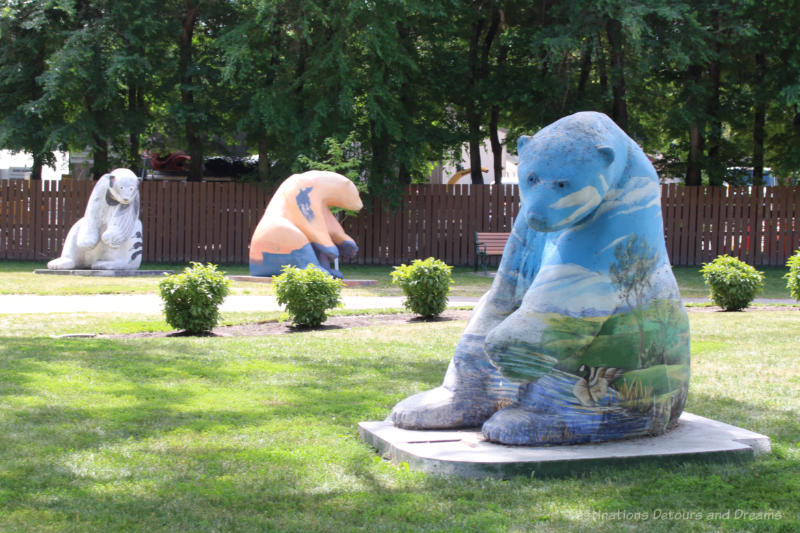 Bears on Broadway Collection of 3 concrete polar bears painted in bright colours and designs sitting in a park