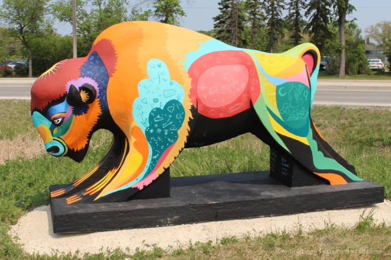 Bisons on the Boulevard Colours of Courage A concrete bison painted with a variety of shapes and images in vibrant colours