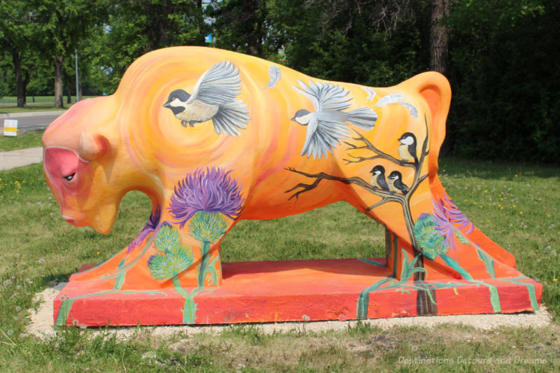 Bison on the Boulevard A Little Resistance Goes a Long Way Concrete bison painted in oranges and yellows contains pictures of black-capped chickadees and the common thistle