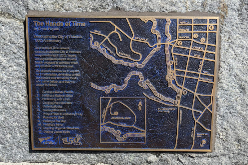Plaque on side of brick wall shows map of locations of 12 public art installations for Victoria's Hands of Time