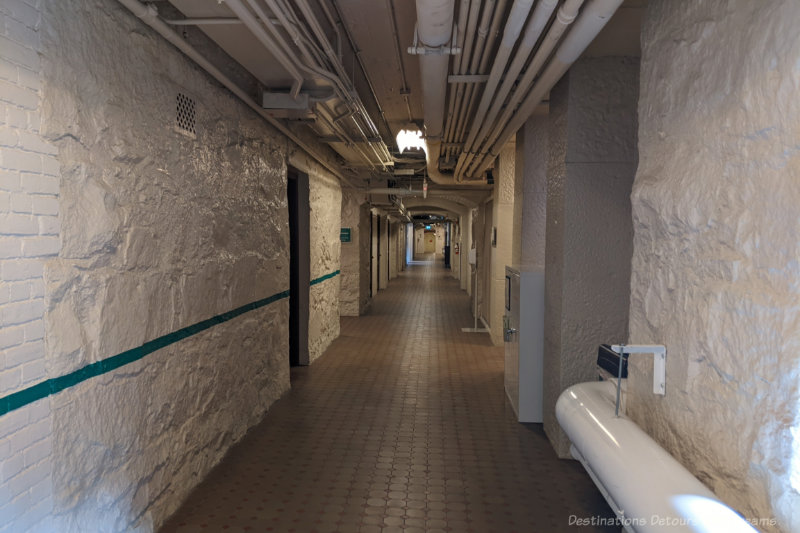 Basement corridor with stone walls and overhead pipes