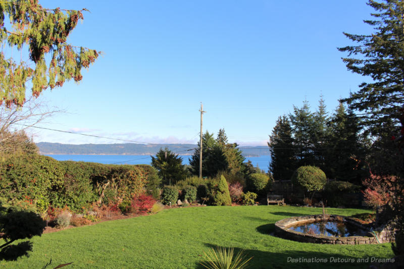 View of ocean in background from a beautifully landscaped yard