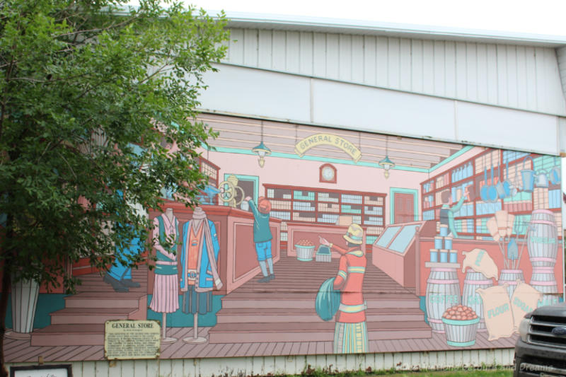 Boissevain Outdoor Art Gallery General Store Mural of a 1922 general store in shades of coral and blue