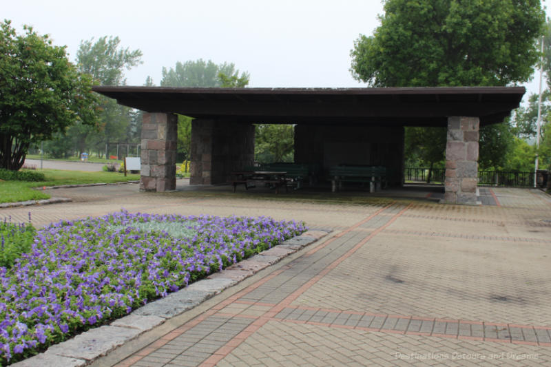 Picnic shelter with brick pillars and wood roof on a brick terrace
