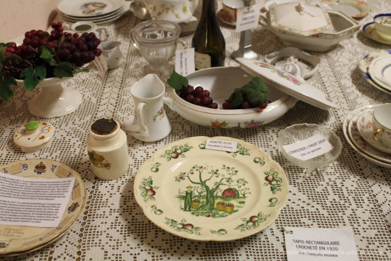 Old French china displayed on a table covered with a white lace cloth