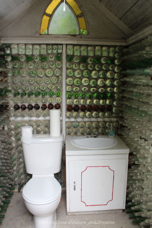 Toilet and hand basin inside a glass bottle restroom house