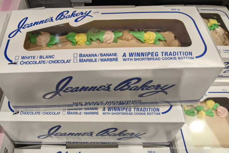 Cake boxes of cakes from Jeanne's Bakery sitting inside a grocery cooler