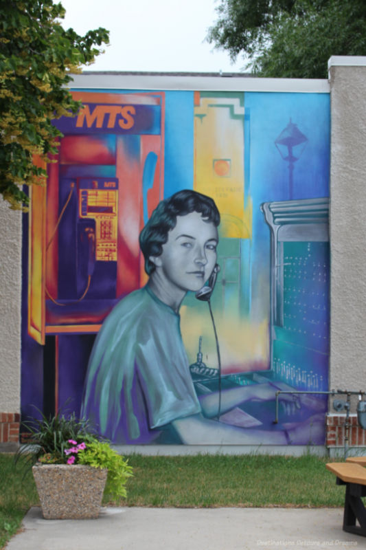 Boissevain Outdoor Art Gallery Switchboard Operator Mural on the outside of a building shows a woman switchboard operator and in the background an old public telephone with letter MTS on it