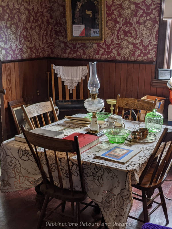 Miami Railway Station Museum Dining Lace covered wood dining table in museum contains antique dishware, lantern, and books of information