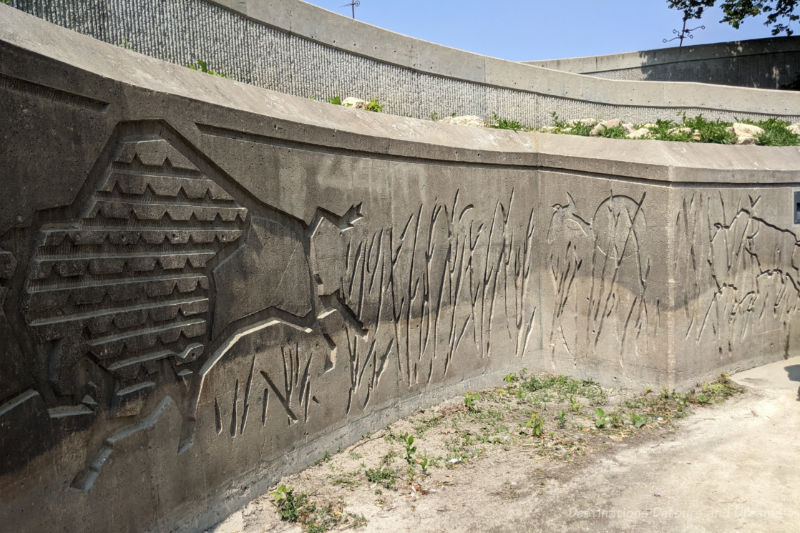 The Forks Turtle Tours Bison Wall Three-quarter height stone wall along pathway contains etchings of bison