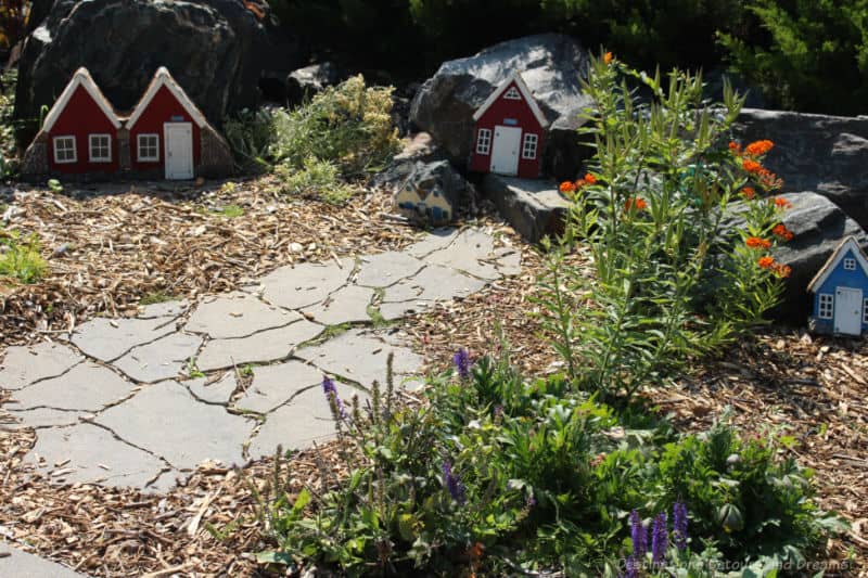 Pathway in garden leading to and past tiny elf houses