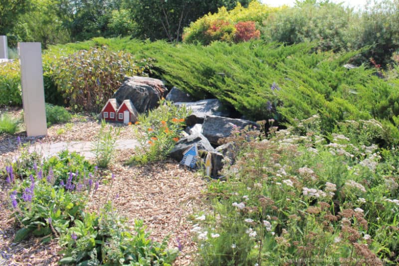 Elf Garden Icelandic Elf Houses in Manitoba - tiny brightly painted house facades tucked into a garden of rock, greenery, and flowers