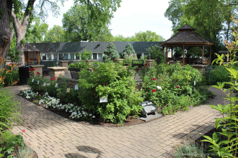 Daly House Museum Victorian Garden Garden of flowers and shrubs with a tiled walkway around it
