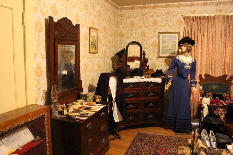 Daly House Museum Bedroom Victorian-era bedroom in a museum features antique dressers and mannequin in vintage dress