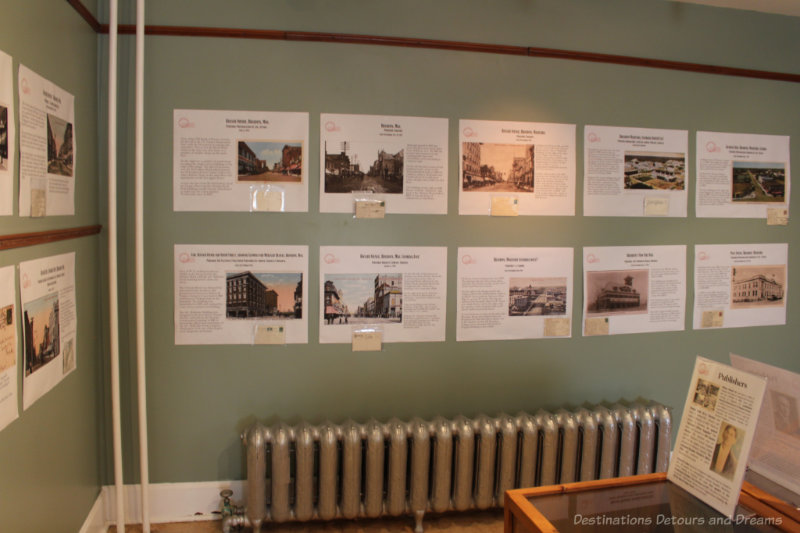 Daly House Museum Building Photographs Green-grey wall containing a collection of photographs of buildings with text about each of them