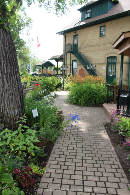 Daly House Museum Garden Pathway Brick pathway through garden leading past the side of two-story brick house to its front