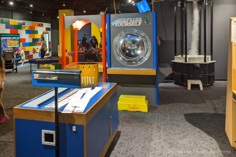 Main area of a science museum shows optical illusion station, animation station, and LEGO station