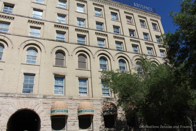 Winnipeg Artspace Building Front of a 6-storey, sandy-coloured brick Richardson Romanesque building constructed in 1900 as a warehouse, now containing art organizations.