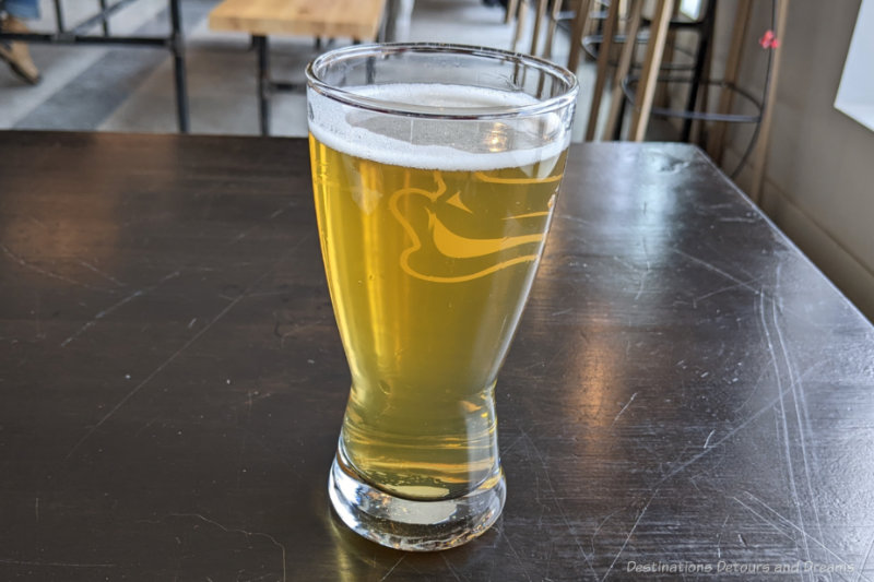 Devil May Care Pilsner A glass of pilsner sitting on a table