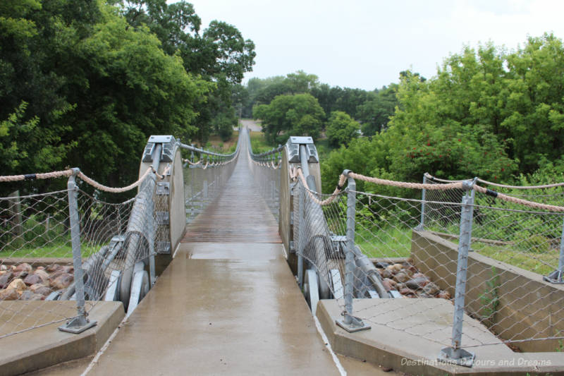 Looking at entrance of one side of pedestrian suspension bridge